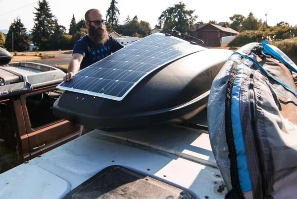 A flexible solar panel being fitted to a vehicle roof
